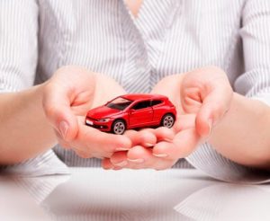 A woman holding a tiny car.