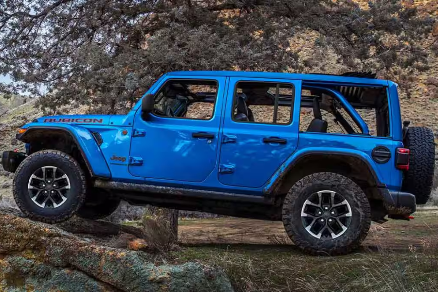Blue Jeep Wrangler Rubicon climbing over rocky off-road terrain